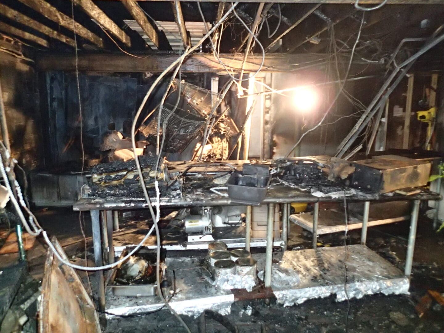 A fire damaged building with wires hanging from the ceiling.