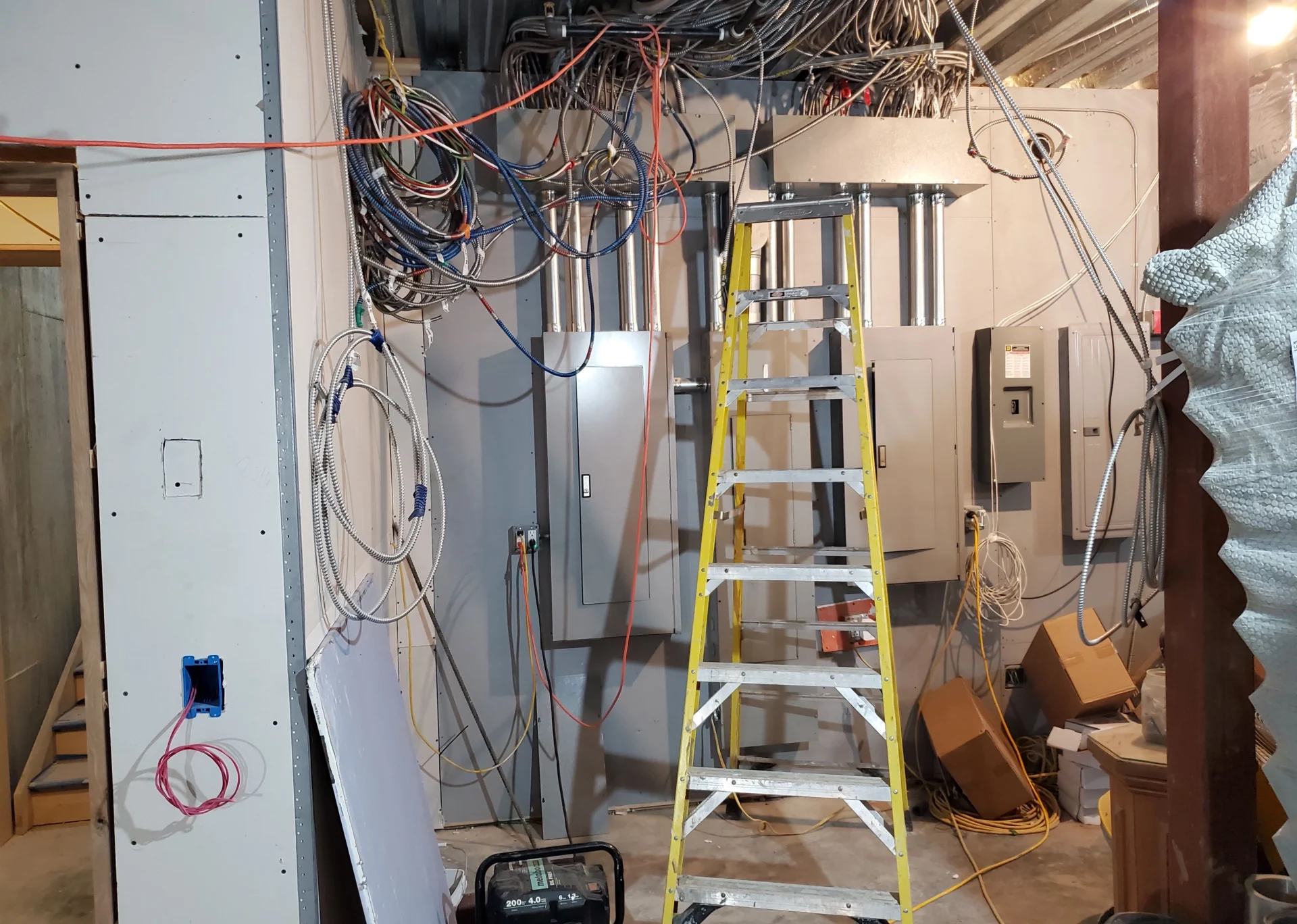 A ladder in the middle of an electrical room.