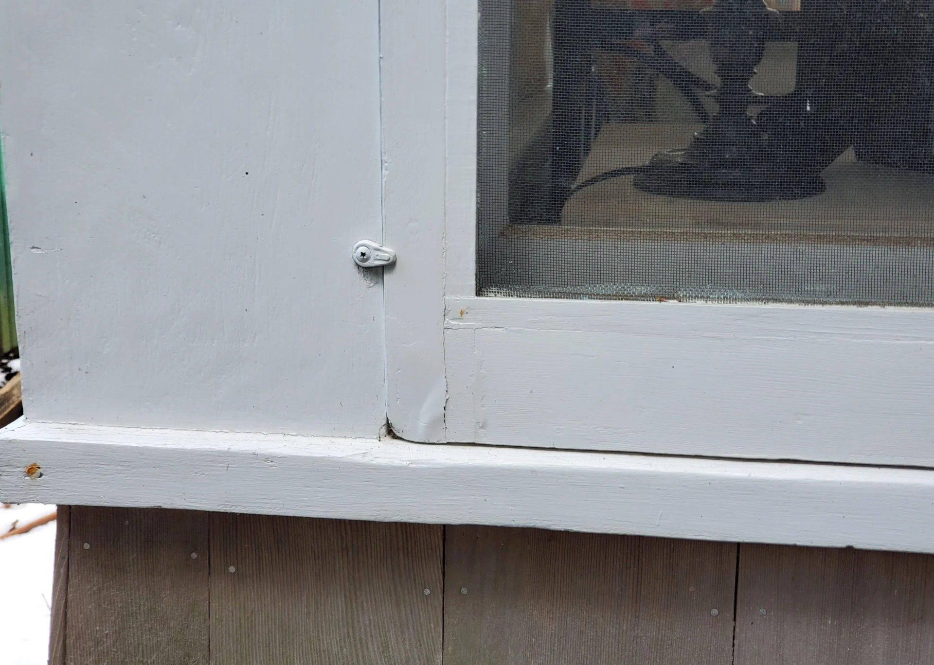A white window sill with a hole in the bottom of it.