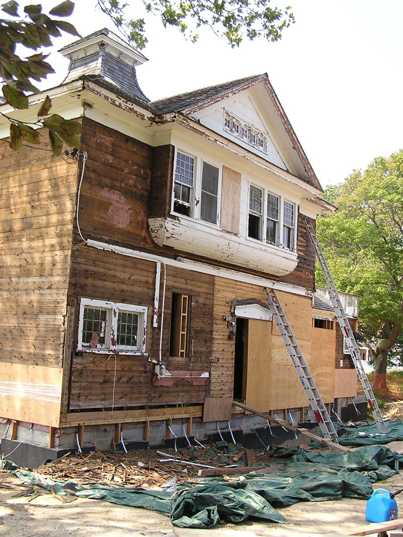 A house being remodeled with scaffolding and wood.