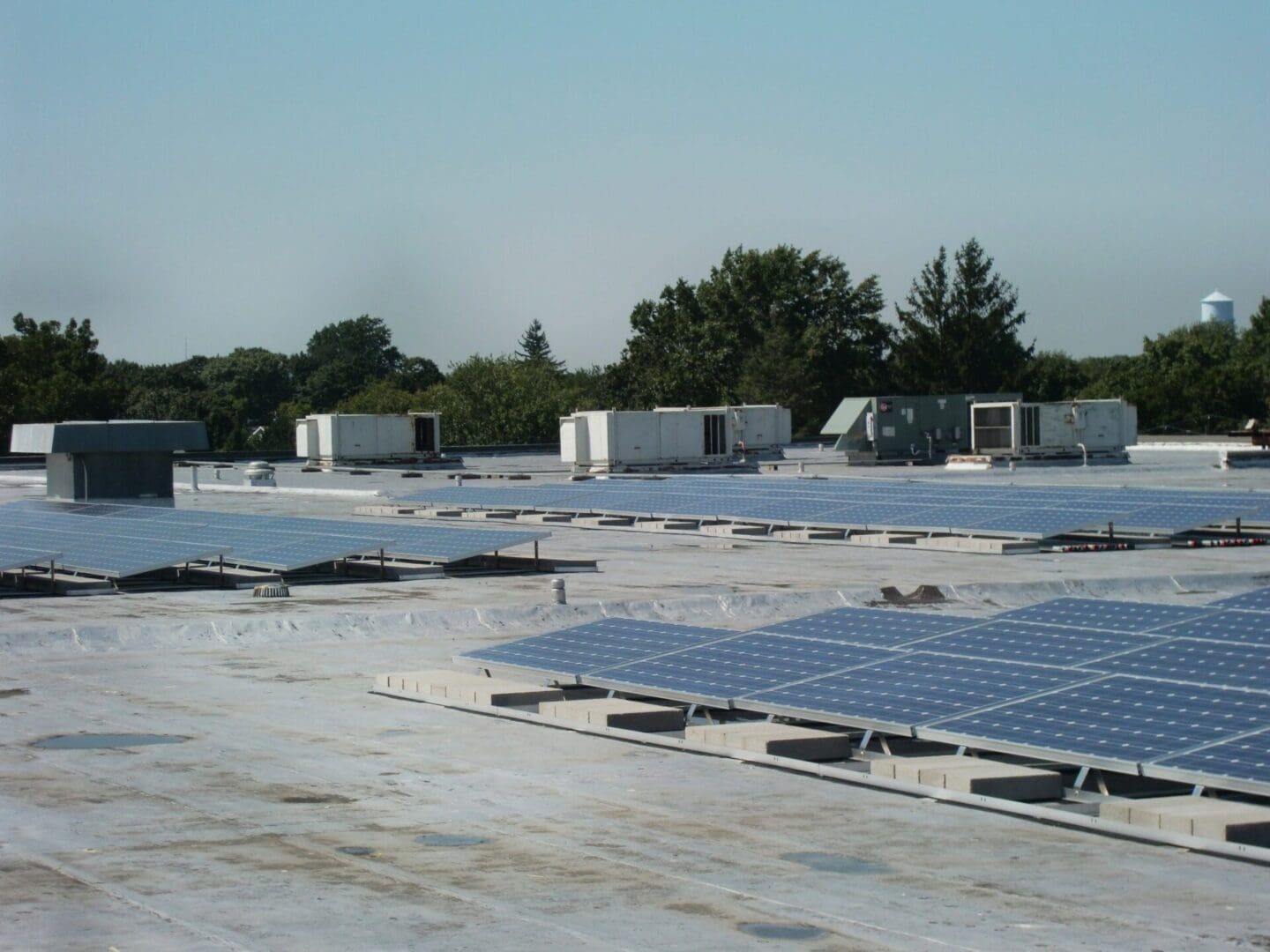 A large field of solar panels on top of concrete.